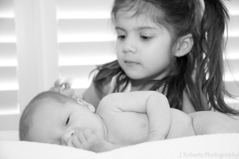 older sister patting newborn baby - baby portrait photography sydney